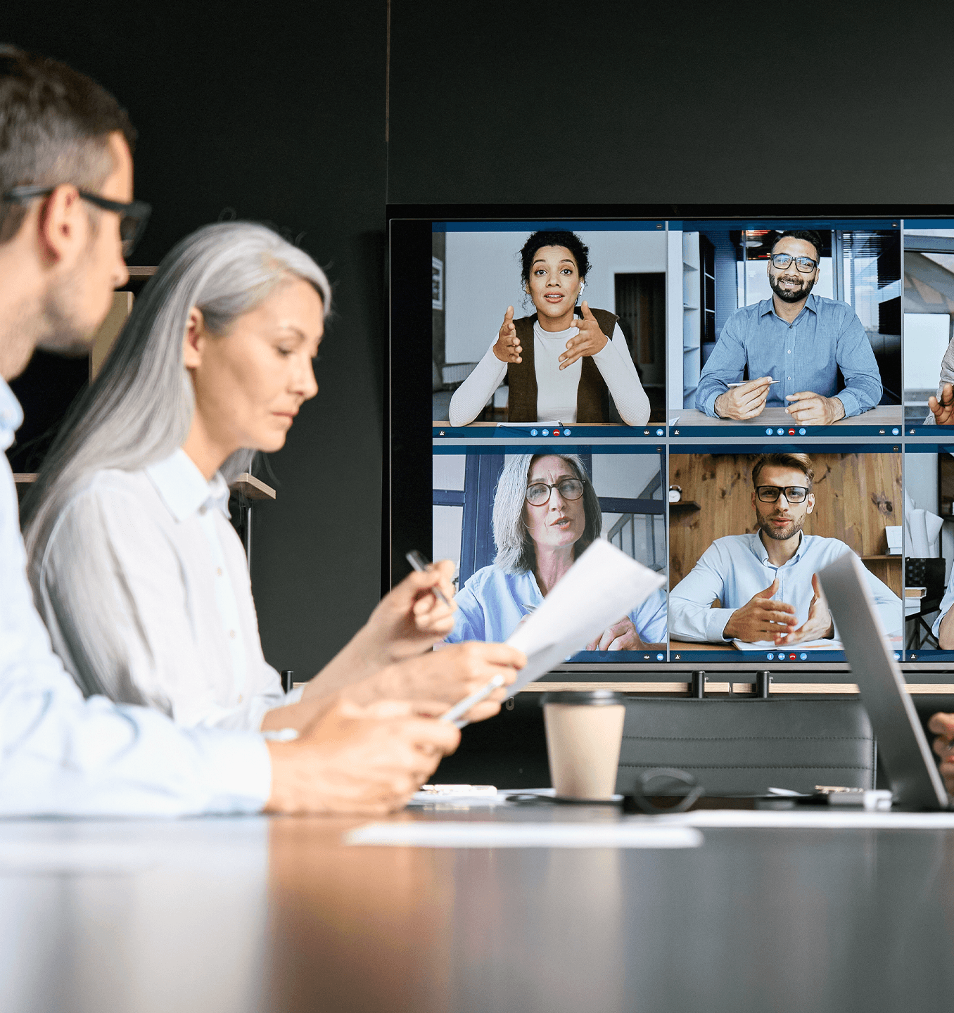 coworkers participating in a video call in a meeting room workspace
